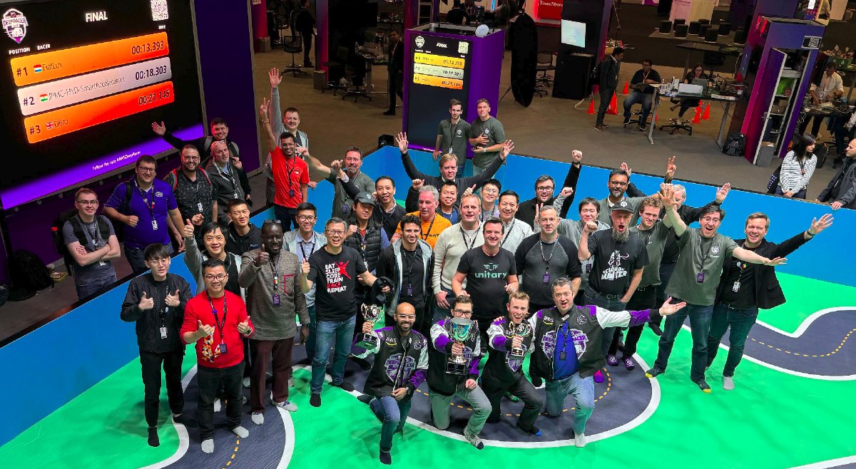 A picture of many AWS DeepRacer Community members on a racing track in 2023